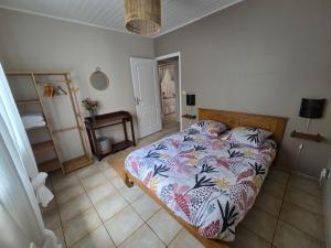 a bedroom with a bed with a floral bedspread at kaz Lé pa si Ô in La Rivière