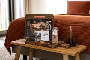 a table with a candle and books on a couch at Hoeve BuytenHout in Delft
