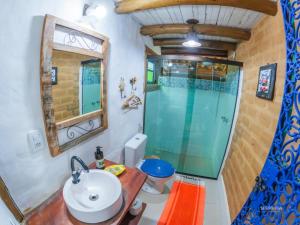 a bathroom with a sink and a shower at Pousada Villa Cachoeira in Carrancas