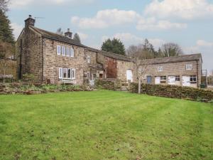an old brick house with a large yard at Barley Cote Farm in Keighley