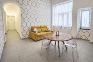 a living room with a table and a couch at Corso Vittorio Elegant Suites Lipari in Lipari +22 photos