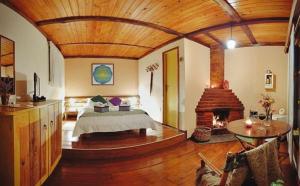 a large bedroom with a bed and a fireplace at Pousada Bocaina in São Pedro da Serra