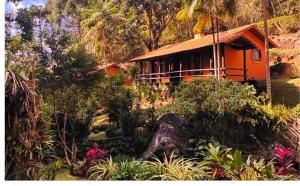 an orange house in the middle of a forest at Pousada Bocaina in São Pedro da Serra