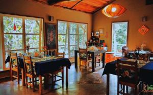 a dining room with tables and chairs and windows at Pousada Bocaina in São Pedro da Serra +80 photos