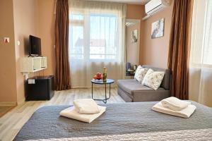 a room with a bed and a living room with a couch at Hotel Leda in Sofia