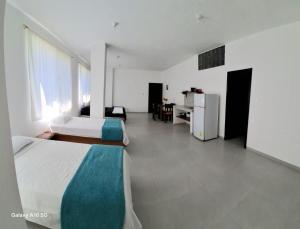 a bedroom with a bed and a desk and a refrigerator at Barrio Central in Puerto Ayora