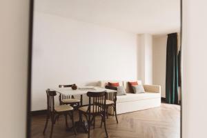 a living room with a white couch and a table and chairs at Honest Granada Apartments in Granada +17 photos
