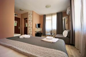 a hotel room with a bed and a couch at Hotel Leda in Sofia