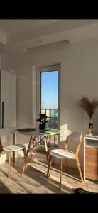 ein Wohnzimmer mit Tisch und Stühlen und einem Fenster in der Unterkunft SunSet Studio by Cosmopolis in Ştefăneştii de Sus