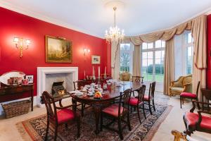 a dining room with red walls and a table and chairs at The Old Rectory in Deal