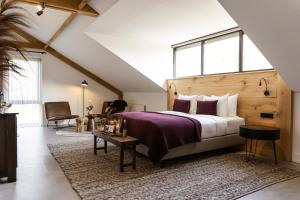 a bedroom with a large bed and a large window at Hoeve BuytenHout in Delft