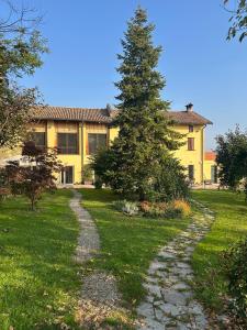 a tree in front of a yellow house at Il Casale in Colcavagno