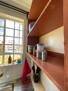 a kitchen with a counter with a sink and a window at Cosy Loft Eldoret in Eldoret +29 photos