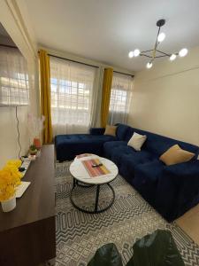 a living room with a blue couch and a table at Cosy Loft Eldoret in Eldoret