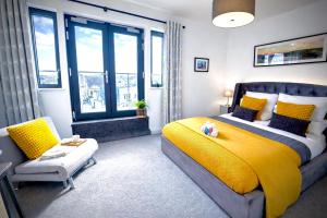 a bedroom with a bed and a yellow blanket at Margate Penthouse Private Balconies Sea Glimpses Gated Parking Air-Con The Penthouse Margate in Margate