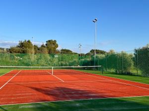 a tennis court with a net on a court at Residence il Mandorlo in Lacona