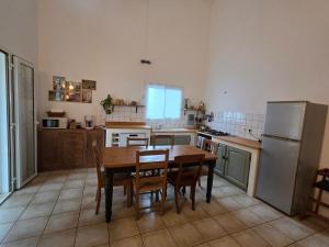 a kitchen with a table and chairs and a refrigerator at kaz Lé pa si Ô in La Rivière
