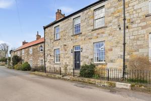 an old stone building with a fence in front of it at Lantern House - North East Escapes in Belford