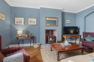 a living room with a couch and a fireplace at Lantern House - North East Escapes in Belford