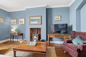 a living room with a couch and a fireplace at Lantern House - North East Escapes in Belford