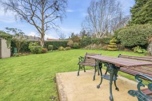 a wooden picnic table and bench in a yard at Lantern House - North East Escapes in Belford