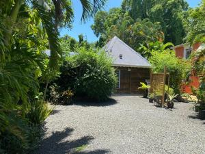 a house with a gravel driveway in front of it at Logement entier, Bungalow ou T2 in Sainte-Rose