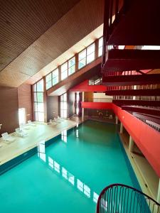 a pool in a building with red stairs and a swimming pool at Leo Loft - Pool, Sauna & Free Parking in San Bernardino