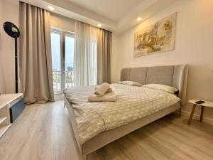 a bedroom with a bed and a large window at Anturium Studio #Otopeni #freePool in Tunari