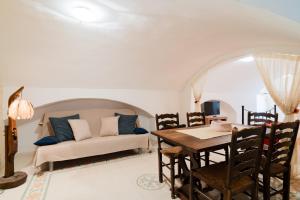 a living room with a table and a couch at Piazzetta San Giovanni Specchia in Specchia