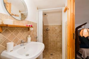a bathroom with a sink and a shower with a mirror at Piazzetta San Giovanni Specchia in Specchia