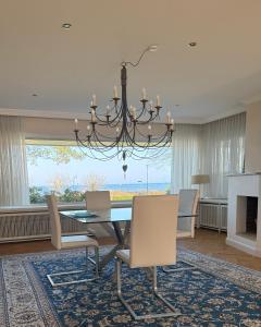 a dining room with a table and a chandelier at Dünenhaus Garten in Timmendorfer Strand