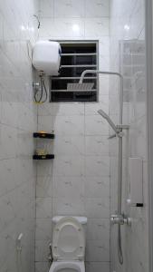 a white bathroom with a toilet and a window at Mielz Apartment in Dar es Salaam +12 photos