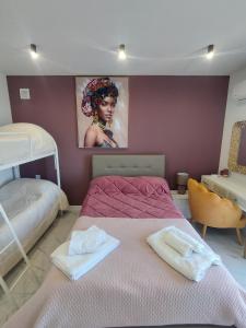 a bedroom with two beds and a painting on the wall at Nela in Carini