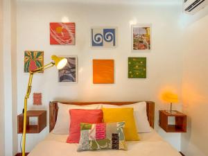 a bedroom with a bed with colorful pillows at Copacabana Siargao Boutique Hotel & Artcafé in General Luna +21 photos