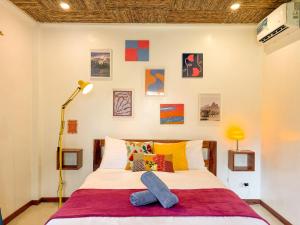 a bedroom with a bed with colorful pillows at Copacabana Siargao Boutique Hotel & Artcafé in General Luna