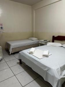 two beds in a room with two bedsvisor at Hotel Realeza in Goiânia