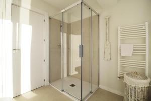 a glass shower in a bathroom with a toilet at Luaña Beach House in Cóbreces
