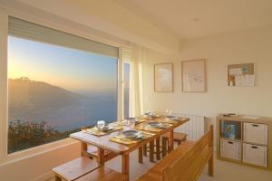 a dining room with a table and a large window at Luaña Beach House in Cóbreces