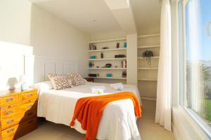 a bedroom with a bed and a window at Luaña Beach House in Cóbreces