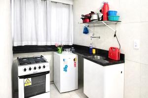 a small kitchen with a stove and a sink at Edifício AES Brasil in Cairu