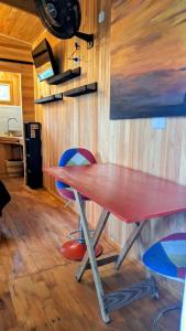 a red table and two chairs in a room at Cabaña Tu Refugio in Paraná