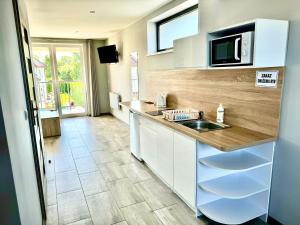 a kitchen with a sink and a microwave at Pensjonat Plaża 2 in Rowy