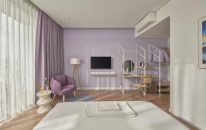 a living room with a bed and a tv at Adela Hotel Dalat in Da Lat +18 photos