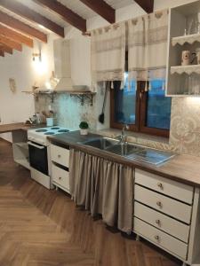 a kitchen with white cabinets and a sink at Vasileris Home in Moúdhros