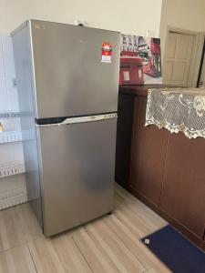 a stainless steel refrigerator in a kitchen next to a counter at PD Laguna Resort Vacation in Kampong Tanah Merah
