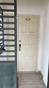 a white door with a sign on it next to a staircase at PD Laguna Resort Vacation in Kampong Tanah Merah