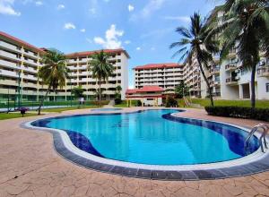 a swimming pool in front of some buildings at PD Laguna Resort Vacation in Kampong Tanah Merah