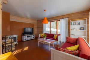 a living room with a red couch and a tv at Vasekoja Holiday Center in Vahtseliina