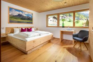 a bedroom with a bed and a desk and a chair at Appartements Veronika in Silbertal +32 photos