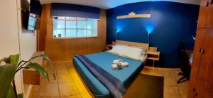 a blue bedroom with a bed and a desk at Punto DF - Airport in Mexico City